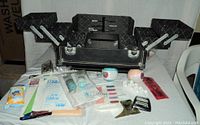 Open makeup case showing multiple compartments and various makeup and bath products arranged in front.