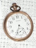 Close-up photo showing the white dial with black numerals and the smaller second hand sub-dial of the Waltham pocket watch.