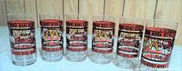 Six clear glasses with McDonald's logo on one side, Coca-Cola logo on the other, bordered by red and black decorative patterns.