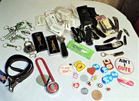 Full overview of the lot showing bag cutters, knives, keychains, pins, and dog collar.