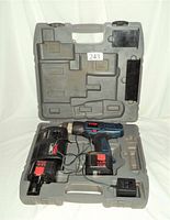 Opened Ryobi molded plastic carrying case with cordless drill, two battery packs, and charger inside.