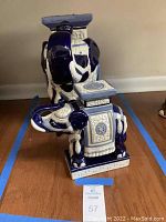 Photo showing both ceramic elephants side by side on the floor with blue tape marking the display area.