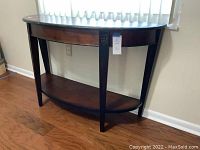 Full view of the half round buffet or foyer table showing shape, legs, lower shelf and overall condition.