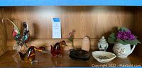Shelf with 3 glass bird figurines, 2 small pottery jars, ceramic dish, artificial flower arrangement