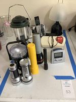 Wide view of lot showing various flashlights, cordless phones, lamp, help emergency phone unit, and atomic clock