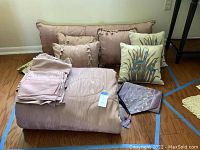 Full view of the bedding set including comforter, pillows, bed skirt sections, and decorative home accessories.