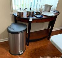 View of all kitchen items on table and garbage can on floor
