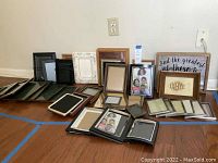 Large group photo frames displayed on floor, various sizes and styles shown