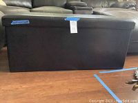 Front view of the brown vinyl storage chest showing size and overall condition.