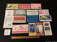 Top-down photo of all 14 advertising blotters arranged flat showing various brand advertisements.