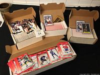 Boxes filled with over 1000 hockey cards laid out on a table including some loose and stacked cards.