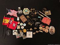Overview of all assorted items including flags, pins, coins, and more arranged on black background.