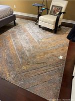 Full view of rug laid out under bed and chair in room