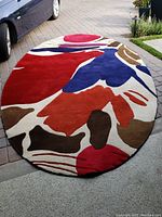 Full view of oval rug laid on driveway showing entire shape and pattern