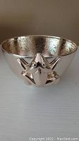 Front angled view showing frog sculpture on bowl exterior and hammered interior