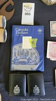 Front of blue vinyl Canada Dollars album labeled “Canada Dollars 1935-Date” alongside two black Canada-crest coin folders