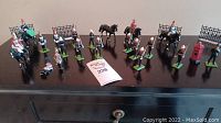 Full view of the military figures collection including multiple mounted RCMP figures, standing police officers, and a red post box on a dark surface.