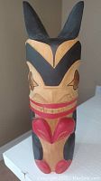 Front view of totem showing full carving and paint detail