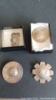 Overview of four pins: two round, one sun-shaped, one turquoise animal-form