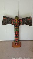Full front view of entire totem pole on base