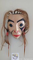 Front view of full mask showing painted features and attached hair