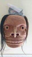 Front view showing full mask carved from light-toned wood with hair attachments and carved facial details