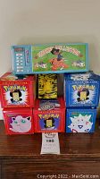 Green rectangular Sticker Collection box atop five Pokéball display boxes