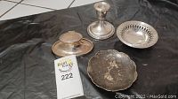 Overview of four silver pieces including pierced dish, candlestick, inkwell and trinket dish