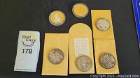 Overview of all six coins including four silver dollars and two commemoratives