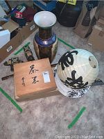 Large ceramic vase, paper lantern with Asian calligraphy, and wooden box with Asian tea set