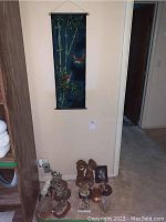 Wide view of the lot showing the bamboo wall scroll hanging and various figurines arranged on the floor.
