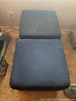 Two blue cube storage seats placed side by side. Fabric shows signs of wear and dirt.