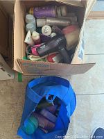Top down view of the box containing the hair dryer and assorted hair care products and accessories