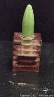 Front view of the antique table lighter showing the green bullet-shaped top on the brown rectangular base.