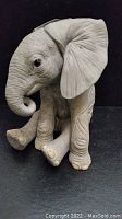 Side profile view of the sitting elephant figurine, showing detailed wrinkles and facial features.