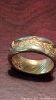 Close up front view of an 18K gold nugget style ring showing its design and texture.
