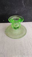 Front view of the green Depression glass candleholder showing its circular base and short stem.