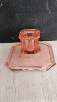 Side view of pink depression glass candleholder showing geometric octagonal base and candle socket.
