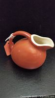 Side view of vintage ceramic creamer pitcher showing round body and handle