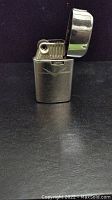 Full view of the vintage Ronson lighter with lid open, showing metal body and ignition area.