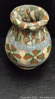Front view of the bulbous, colorful patterned ceramic vase with a rolled rim and narrow neck