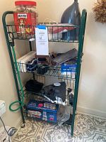 Front view of green 4 shelf wire rack with various items on each shelf for scale. Rack is clean, lightly used.