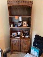 Full view of the solid wood bookcase showing shelves and cabinet doors with brass hardware.