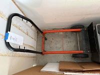 Top view of the dolly showing the handle, orange frame, and wheels.