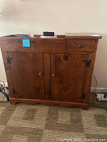 Front view of a dark solid wood dry sink cabinet with drawer on right and double-door storage underneath