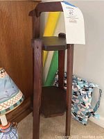 Photo of the small wooden circular shelf with two levels and dark brown finish.