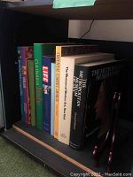 View of the full row of coffee table books showing spines with titles related to art museusm catalogs, culinary, design, and LIFE magazine.