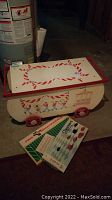 Wooden toy chest with red wheels and marching band design. Boxed checker set and Pro Quarterback game displayed in front.