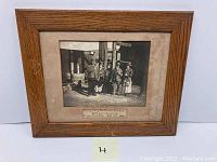 Framed vintage black and white photo showing miners and possibly women outside mine building.