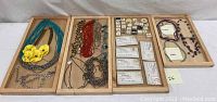 Full lot overview showing multiple wooden trays with necklace pieces including gemstone bead necklaces and metal chain costume necklaces.
